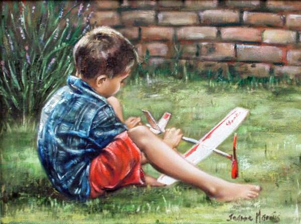 Imagine - Giclée print of oil painting of a young boy sitting on the grass, focused on building a model plane. He wears a blue shirt and red shorts. A brick wall and foliage are in the background